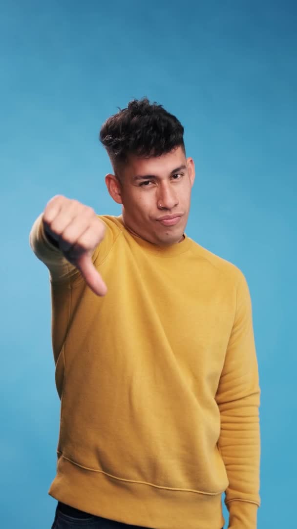 Unsatisfied Man Looking Camera Showing Thumb While Standing Blue Background — Stock Video