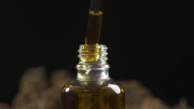 Tıbbi CBD yağ tedavisi ve üretimi kavramı. Pipetten yağ düşüşünün makro görüntüsü çok yakın.