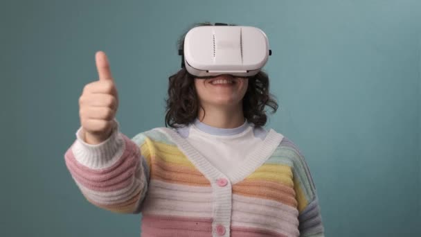 Женщина Показывает Большой Палец Использовании Виртуальной Реальности Гарнитуры Синем Фоне — стоковое видео