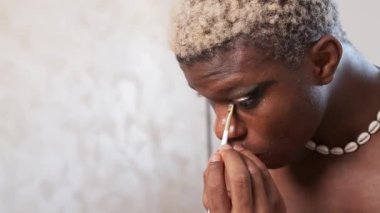 Gözlerine makyaj yapan Afrikalı bir transseksüelin yakın çekimi..