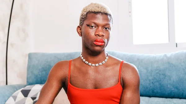 Transgender Osoba Portret Makijażem Czerwona Sukienka Patrząc Aparat Podczas Siedzenia — Zdjęcie stockowe