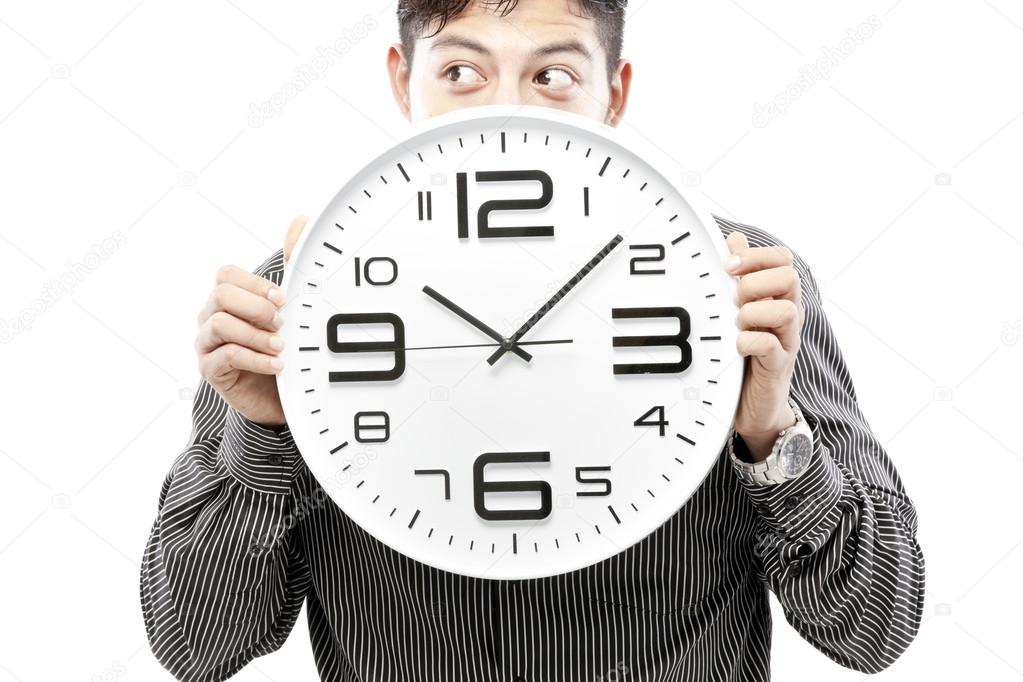 Businessman holding big clock