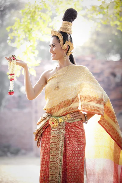 タイ様式の寺院の背景を持つ典型的なタイのドレスを着ている女性 — ストック写真