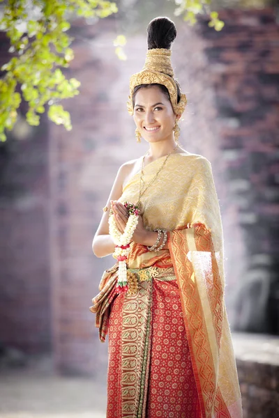 Vrouw dragen typisch Thaise jurk met Thaise stijl tempel achtergrond — Stockfoto