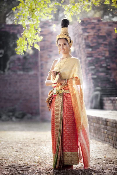 Vrouw dragen typisch Thaise jurk met Thaise stijl tempel achtergrond — Stockfoto
