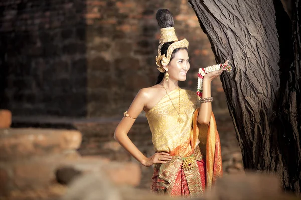 Frau trägt typisches thailändisches Kleid mit Tempelhintergrund im thailändischen Stil — Stockfoto
