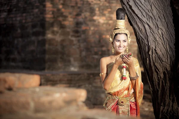 Kvinnan bär typiska thailändska klänning med thailändsk stil tempel bakgrund — Stockfoto