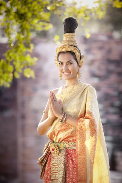 Vrouw dragen typisch Thaise jurk met Thaise stijl tempel achtergrond — Stockfoto