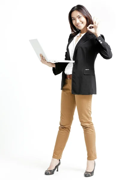 Young businesswoman holding her laptop and giving ok hand sign — Stock Photo, Image