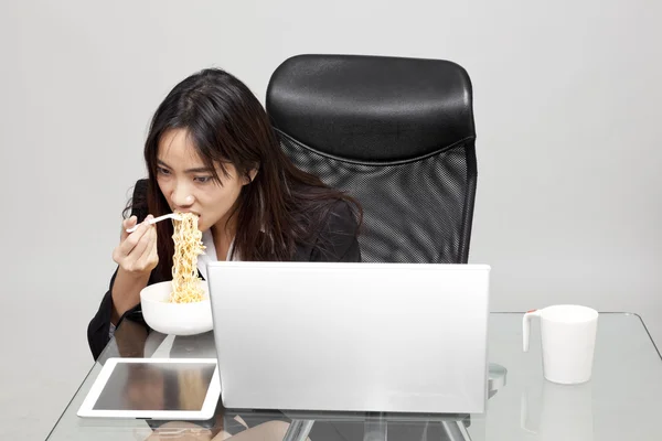 Mulher trabalhadora que come alimentos insalubres durante a hora do escritório . — Fotografia de Stock