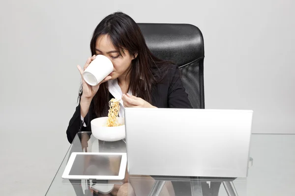 Vrouw werknemer ongezond eten tijdens het uur office. — Stockfoto