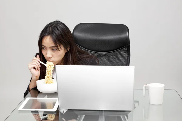 Vrouw werknemer ongezond eten tijdens het uur office. — Stockfoto