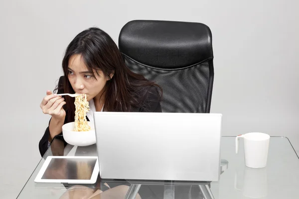 Mujer trabajadora comiendo alimentos poco saludables durante la hora de la oficina . — Foto de Stock