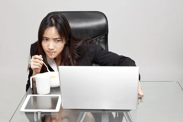 Mujer trabajadora comiendo alimentos poco saludables durante la hora de la oficina . — Foto de Stock
