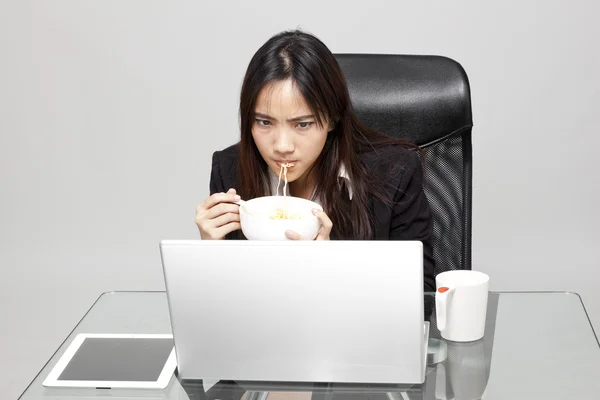 Vrouw werknemer ongezond eten tijdens het uur office. — Stockfoto
