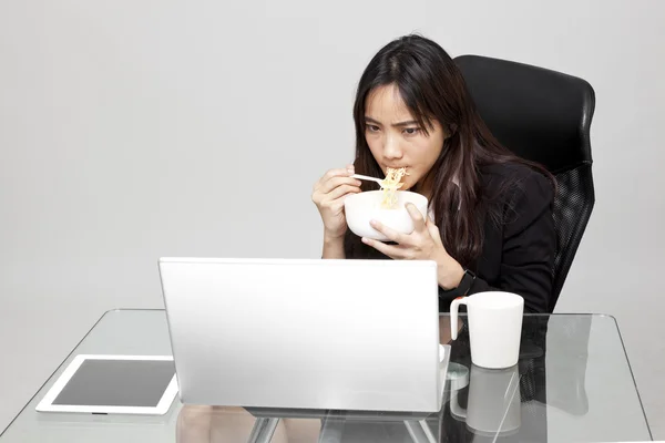 Sağlıksız yemek yeme sırasında yazıhane saat işçisi kadın. — Stok fotoğraf