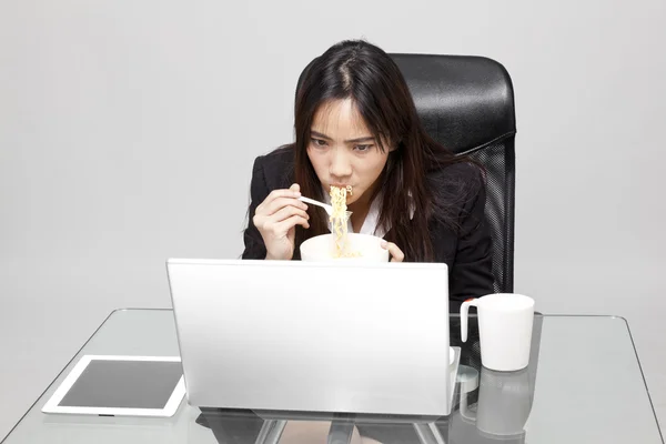 Mulher trabalhadora que come alimentos insalubres durante a hora do escritório . — Fotografia de Stock