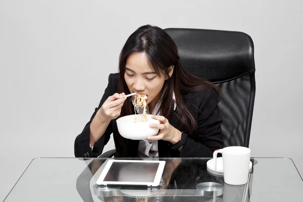 Sağlıksız yemek yeme sırasında yazıhane saat işçisi kadın. — Stok fotoğraf