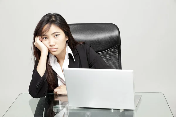 Mujer aburrida en su escritorio — Foto de Stock