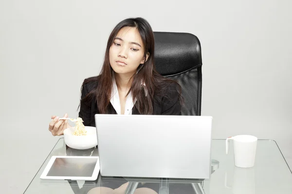 Vrouw werknemer ongezond eten tijdens het uur office. — Stockfoto