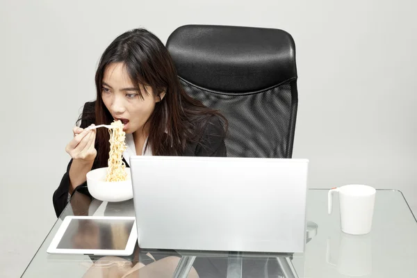 Arbeiterin isst während der Bürozeit ungesundes Essen. — Stockfoto