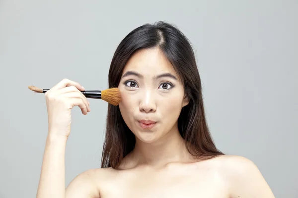 Портрет красивой женщины с кисточками для макияжа возле привлекательного лица. — стоковое фото