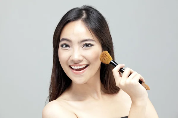 Porträt der schönen Frau mit Make-up-Pinseln in der Nähe attraktiven Gesicht. — Stockfoto