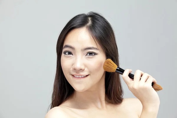 Retrato de la hermosa mujer con pinceles de maquillaje cerca de la cara atractiva. — Foto de Stock