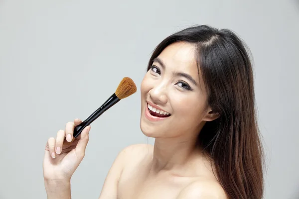 Porträt der schönen Frau mit Make-up-Pinseln in der Nähe attraktiven Gesicht. — Stockfoto