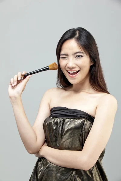 Портрет красивой женщины с кисточками для макияжа возле привлекательного лица. — стоковое фото