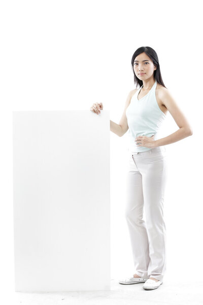 Casual woman standing behind a blank board on white background (green concept)