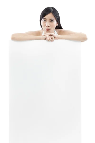 Wanita santai berdiri di belakang papan kosong dengan latar belakang putih (konsep hijau ) — Stok Foto
