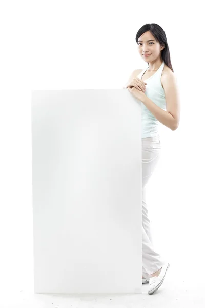 カジュアルな女性の白い背景 (グリーン コンセプトの空白板の後ろに立って) — ストック写真