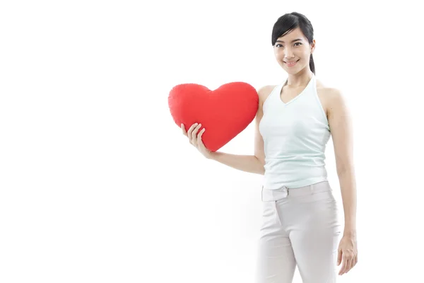 Ritratto di attraente asiatica sorridente donna e mano che tiene il cuore rosso isolato su bianco studio girato — Foto Stock