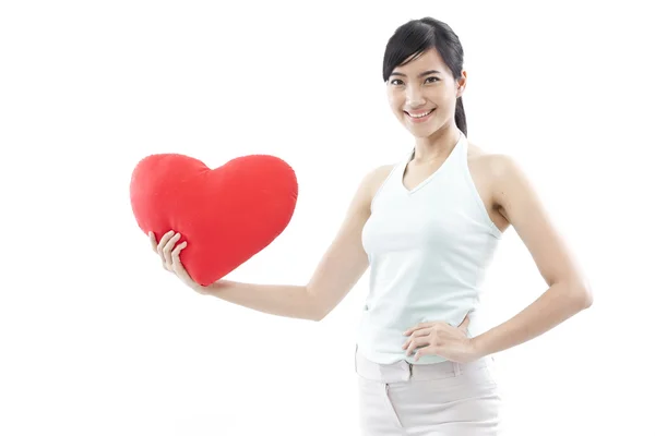 Ritratto di attraente asiatica sorridente donna e mano che tiene il cuore rosso isolato su bianco studio girato — Foto Stock