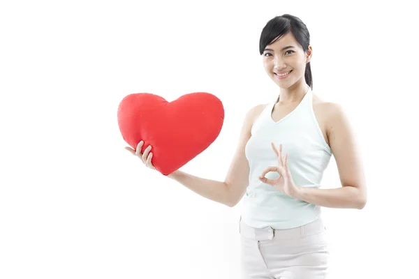 Ritratto di attraente asiatica sorridente donna e mano che tiene il cuore rosso isolato su bianco studio girato — Foto Stock