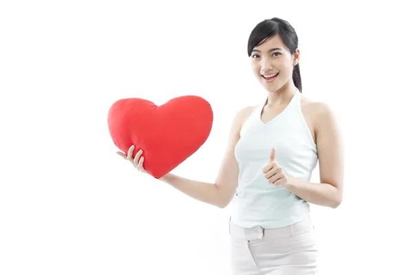 Portrét atraktivní asijské usmívající se žena a ruka drží červené srdce izolovaných na bílém studio záběr — Stock fotografie
