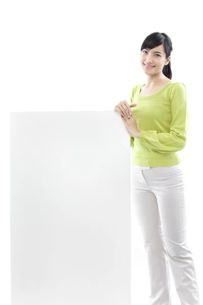 Casual vrouw stond achter een leeg bord op witte achtergrond (groene concept) — Stockfoto