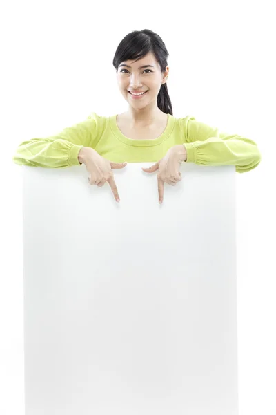Mulher casual em pé atrás de uma placa em branco no fundo branco (conceito verde ) — Fotografia de Stock
