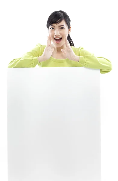 Donna casual in piedi dietro una tavola bianca su sfondo bianco (concetto verde ) — Foto Stock