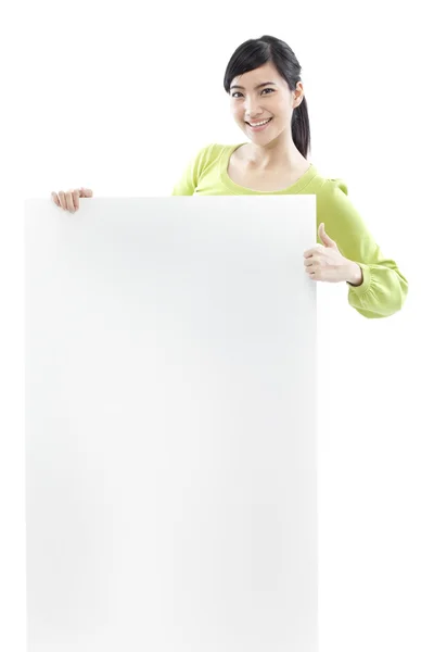 Casual woman standing behind a blank board on white background (green concept) — Stock Photo, Image