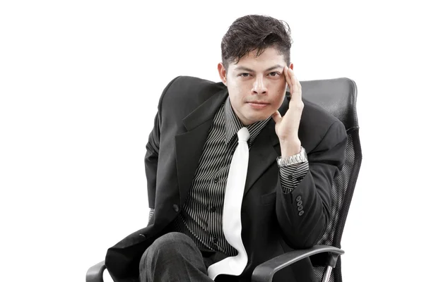 Young businessman sitting on chair, against white background — Stock Photo, Image