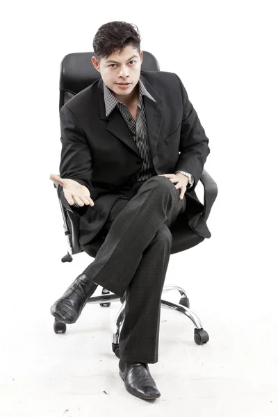 Fiatal üzletember ül a székre, fehér háttér — Stock Fotó