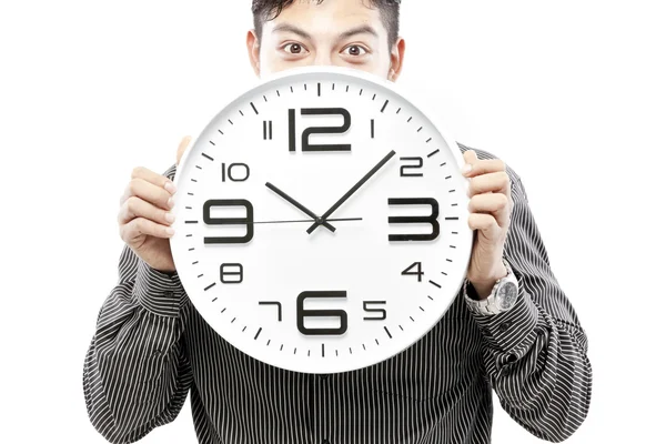 Pojem o čase, podnikatel drží velké hodiny a dát výraz na tváři — Stock fotografie