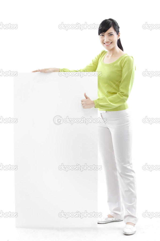 Casual woman standing behind a blank board on white background (green concept)