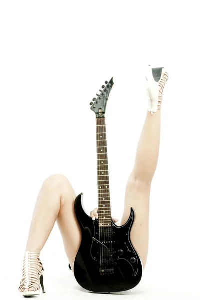 Kép a tojásrakás nő gazdaság gitár előtte, és a lába, mint fehér háttér között — Stock Fotó