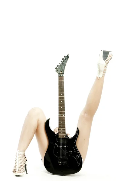 Kép a tojásrakás nő gazdaság gitár előtte, és a lába, mint fehér háttér között — Stock Fotó