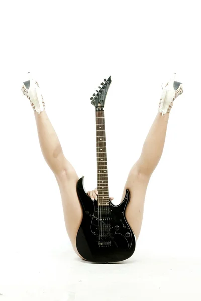 Imagem de uma mulher deitada segurando guitarra na frente dela e entre as pernas sobre o fundo branco — Fotografia de Stock