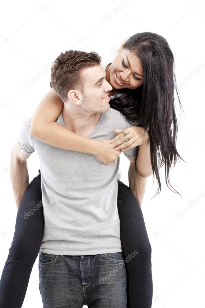 Portrait of a happy young man giving a piggyback ride to her girlfriend against white background