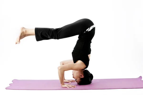 Portrait of a cute young asian female practicing yoga on a mat — Stock Photo, Image